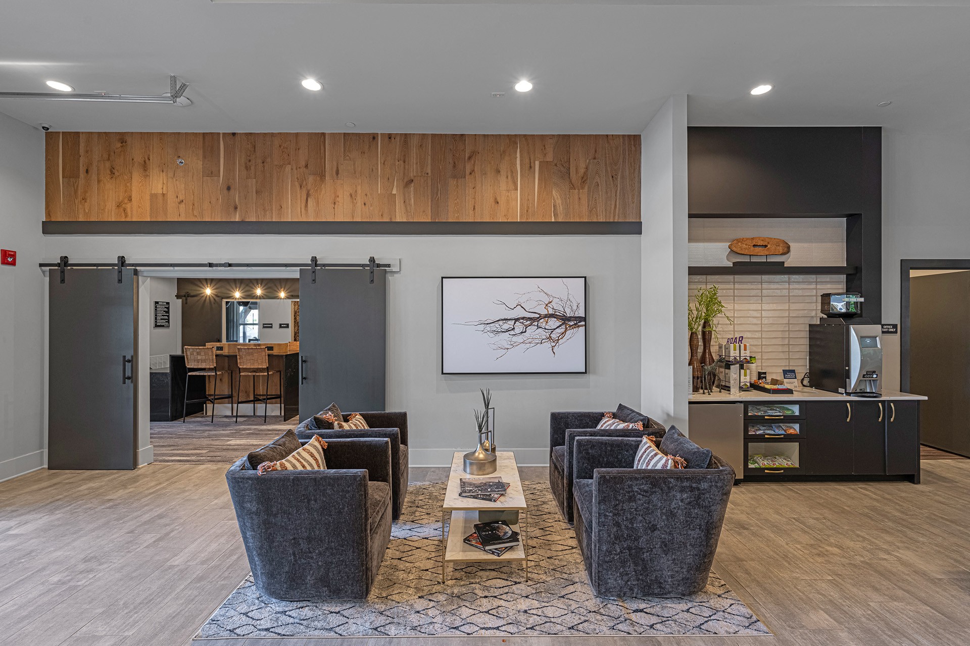a living room with couches and chairs and a kitchen